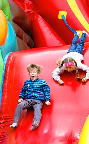 Kids Sliding Down a Moon Bounce
